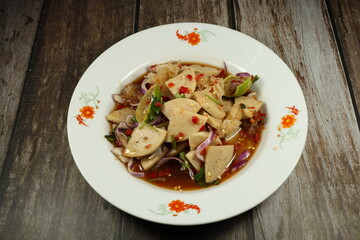 Traditional spicy salad of pork sausage and mixed vegetable serving on the plate. Famous street food menu in Asia.