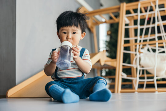 Asian little baby boy sitting and drinking milk