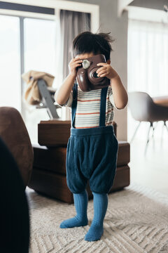 Asian little baby boy using a camera