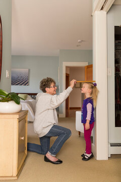 Grandmother Measuring height of Granddaughter  