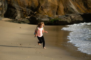 Little athlete in training. Runner exercising, jogging for kids. Child run at seaside. Kids running on beach. Summer vacation. Happy kid boy playing on beach. Happy childhood.