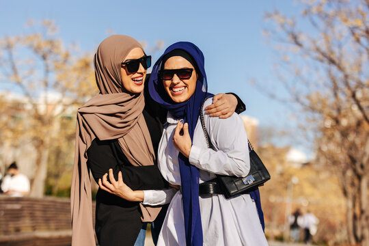 Cheerful muslim women in trendy clothes and sunglasses