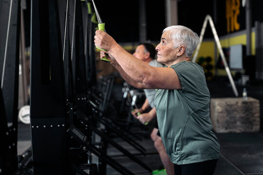 Mature female doing triceps exercise in gym
