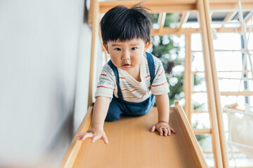 Asian little baby boy playing slide