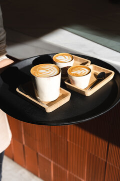 Waitress serving coffees with latte art