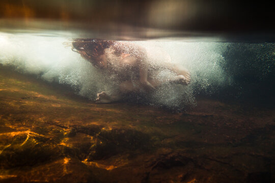 Underwater woman flowing with river stream