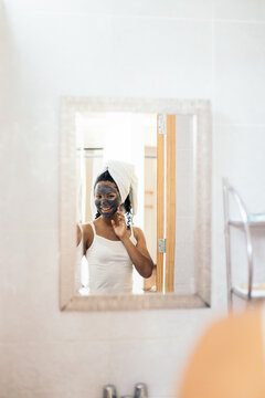 Woman looking in the mirror during skin care