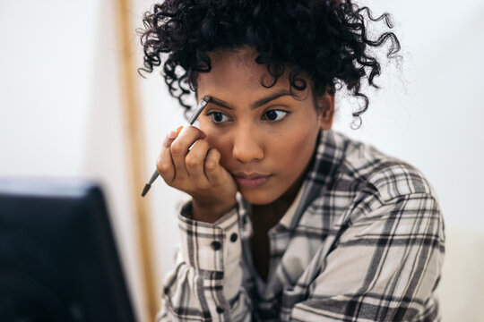 Young latin woman doing makeup at home