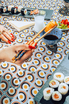 Stylish female eating with chopsticks seafood.