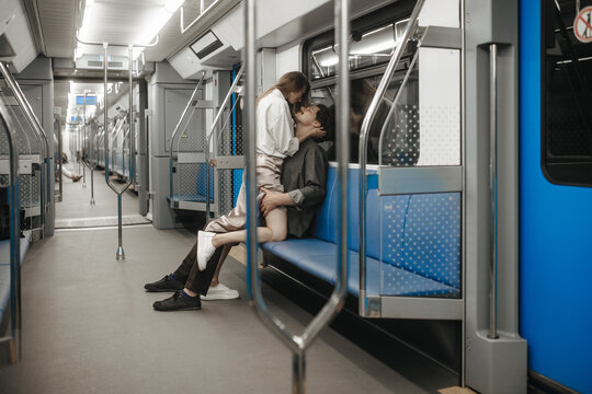 A couple in love passionately embraces in an empty subway car