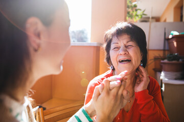 Granddaughter holding hand to her grandmother