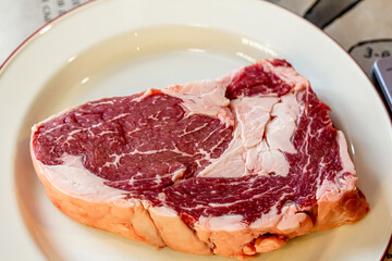 A rib-eye cut of good marbled beef lies in the restaurant, waiting to be cooked