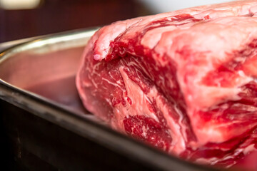 A rib-eye cut of good marbled beef lies in the restaurant, waiting to be cooked