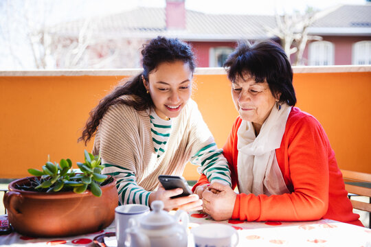 Granddaughter and her grandmother using cellphone