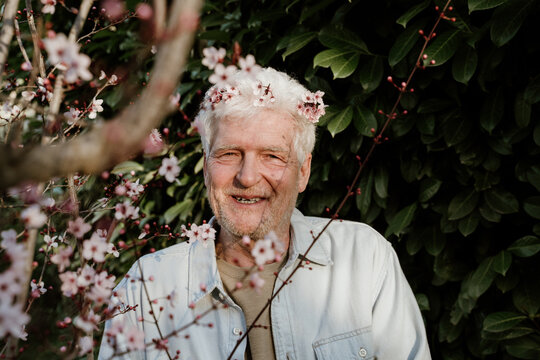 Portrait of happy senior man with flowers on his hair