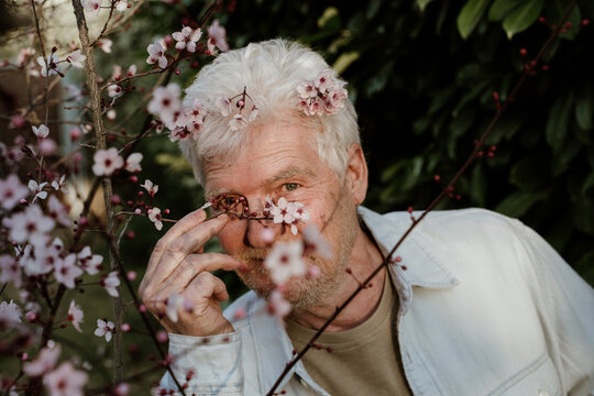 Portrait of happy senior man with flowers on his hair