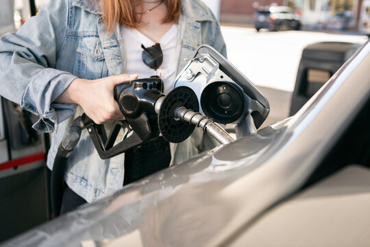 Woman Inserts Gas Nozzle Into Tank