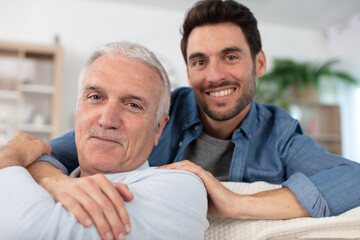 happy old senior dad embracing grown son