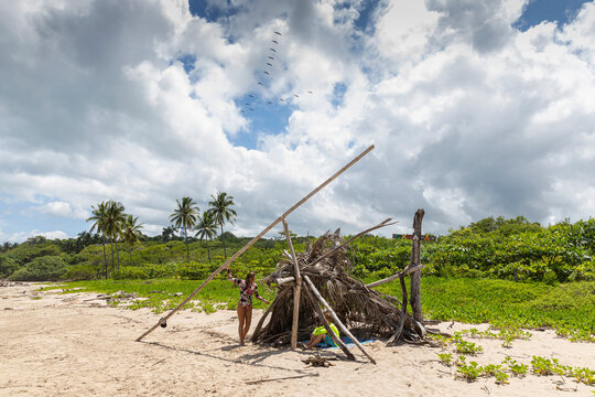 Mother and son bonding at beach hut made of driftwood in Costa Rica