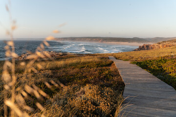 Sunset beach landscape with wooden path to the sea