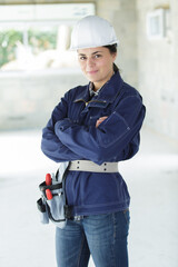 smiling constructor worker woman standing with arms crossed