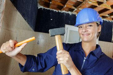 portrait of female worker using hammer and chisel