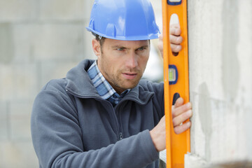 worker with wall with level