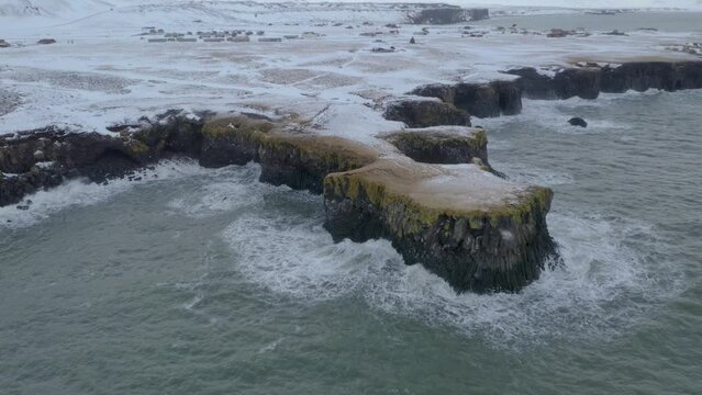 Rough Waves Breaking On Rocky Shoreline Of Arnarstapi At Winter In Iceland. - aerial pullback