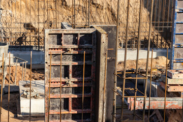 Monolithic foundation with metal reinforcement. Forms vertical formwork structures for the basement of a residential building. Monolithic concrete foundation. Support foundation. Home construction.