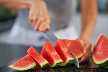 Nice adult woman with watermelon in the kitchen