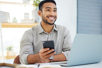 Just got my salary. Shot of a young man using his cellphone at work in a modern office.