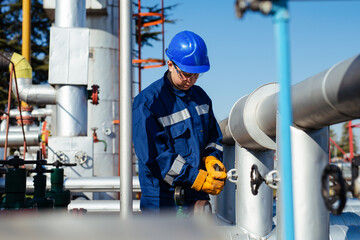 Worker adjusting gauge at oil refinery