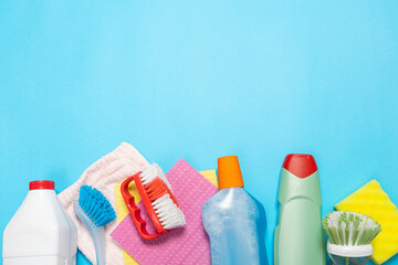 bottles of household chemicals spray and sponges for cleaning and washing on a blue isolated background. Cleaning concept. Banner.