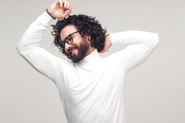 Relaxed man stretching himself and smiling happily in studio