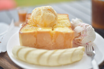 Honey toast with banana on white plate.
