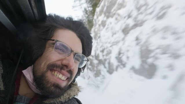 Bearded Male Wearing Glasses Smiling With Head Out Of Open Window On Train. Slow Motion