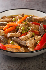 Igado is a Filipino spiced pork and liver dish closeup in the plate on the table. Vertical