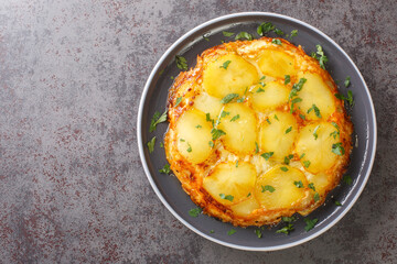 Pan haggerty is a simple one pot, stove top dish made with potatoes, onion and cheese closeup in the plate on the table. Horizontal top view from above