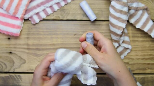 How to make an Easter bunny. Materials for toys towel, scissors, thread. DIY concept. Step-by-step photo instruction. Step 3.Tie it with a thread, you will get a rabbit's muzzle.