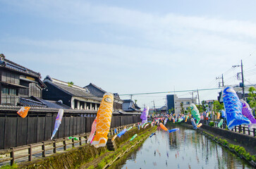 Fototapeta na wymiar The Japanese Carp Fish Flags at The storehouses along the shore of the Uzumagawa River in Tochigi town.The Japanese letters means The History and Legend of Togichi town. 