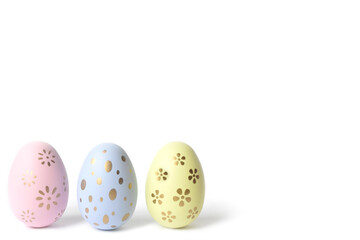 Three pastel coloring eggs in cardboard box on isolated wthite background. Selective focus.