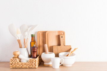 Fototapeta na wymiar environmentally friendly items of modern utensils on a kitchen wooden countertop near a white textured wall. eco-friendly materials without plastic.