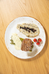 Grilled beef steak served on a plate with asparagus and mushroom sauce