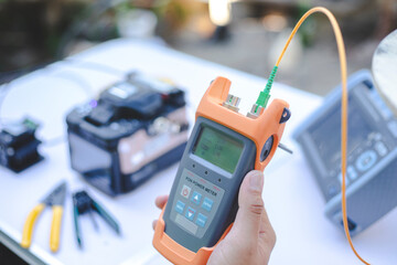 Internet technicians are measuring light signals using power meter tools to measure light intensity with accuracy and precision.