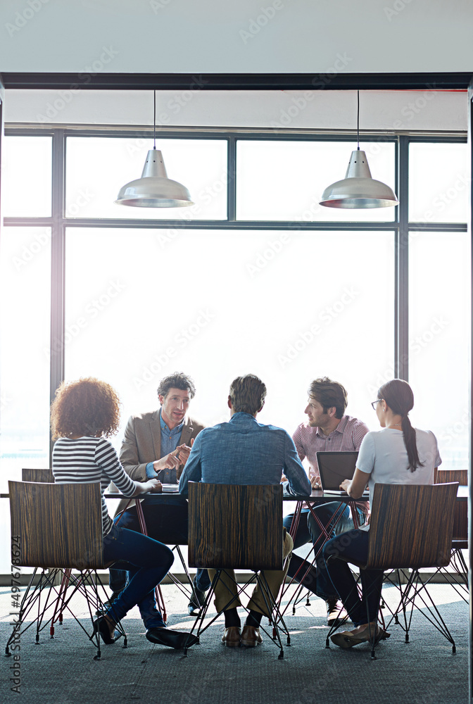 Poster the round table of great ideas. shot of a group of coworkers having a brainstorming session in an of