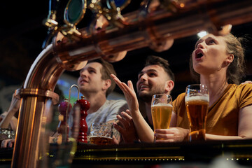 Group of friends cheering to soccer match in the pub