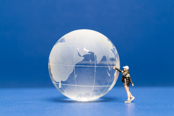 Miniature people Teenager spraying paint crytal globe on blue background ,World environment day concept