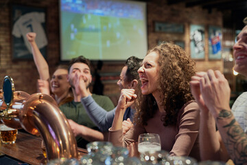 Cheering friends of soccer fans in the pub
