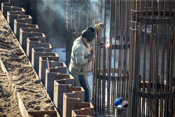 Steel welding or welder outdoors with welding smoke. Harm to the health of the welder will cause inhalation of smoke when welding steel.