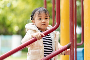 Fototapeta premium Adorable little girl having fun in the outdoor playground.